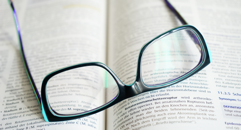 oculos em cima de livro ou dicionario gerenciamento de alarmes